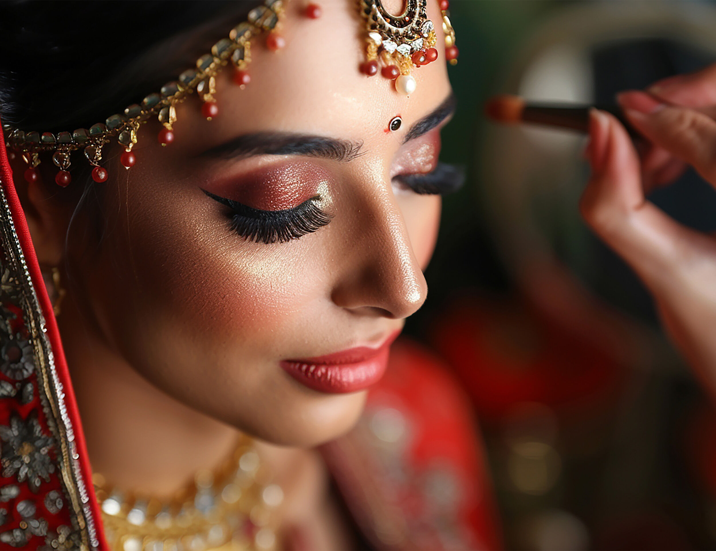 A bride gettimg her makeup done by makeup artist for her wedding